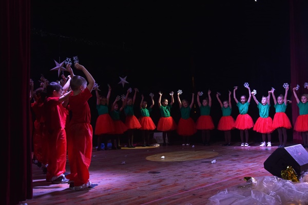 dzieci tańczą na scenie w strojach świątecznych